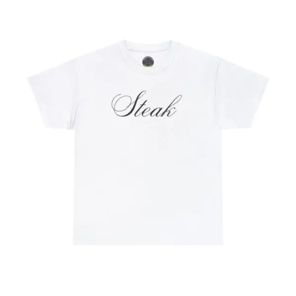 The Steak Tee is a plain white t-shirt that features the word "Steak" printed in elegant script across the chest, offering a perfect minimalist design. Laid flat against a white background, it invites you to embrace its effortless style.