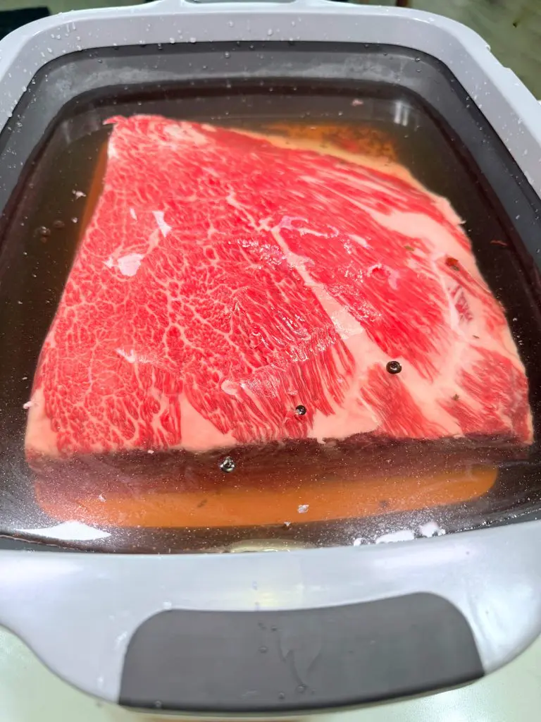 pastrami beef ribs soaking in brine solution before going into the fridge