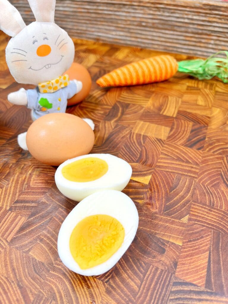 hard boiled eggs sliced in half on a wooden cutting board.