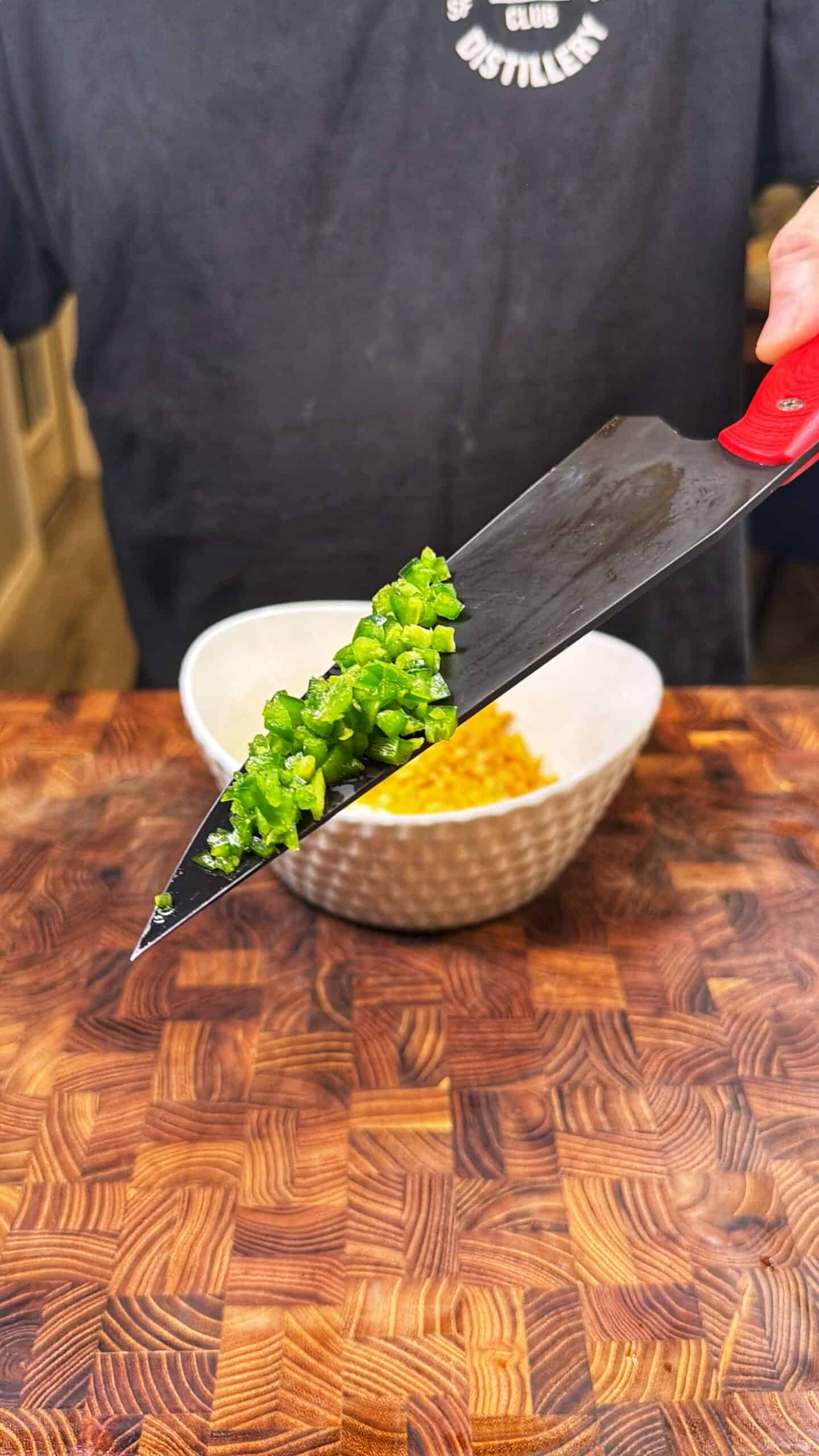 A knife with green peppers on it.