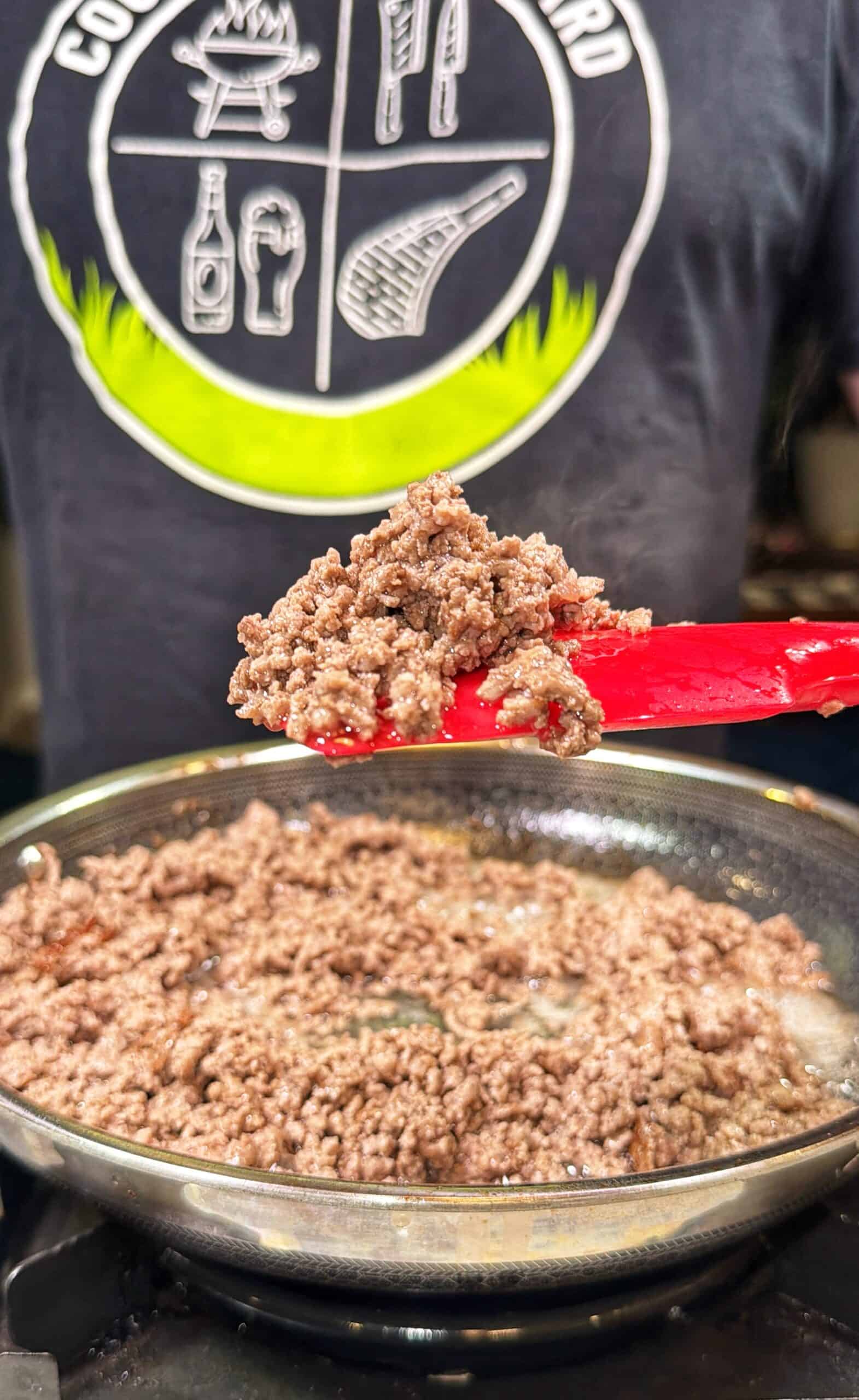A close-up of cooked ground beef in a skillet, with a red <a href=