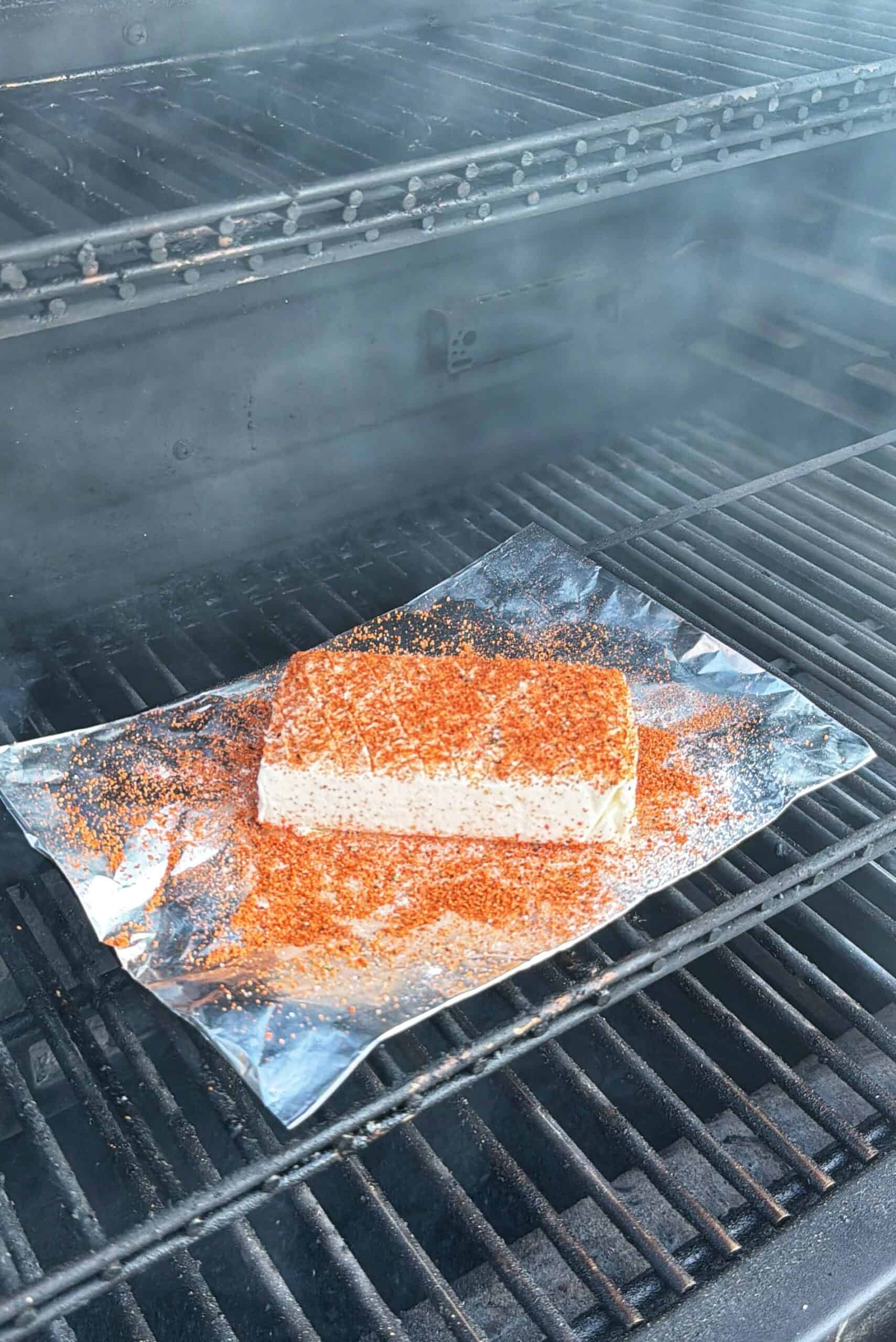 A block of tofu covered in spices sits on a sheet of <a href=