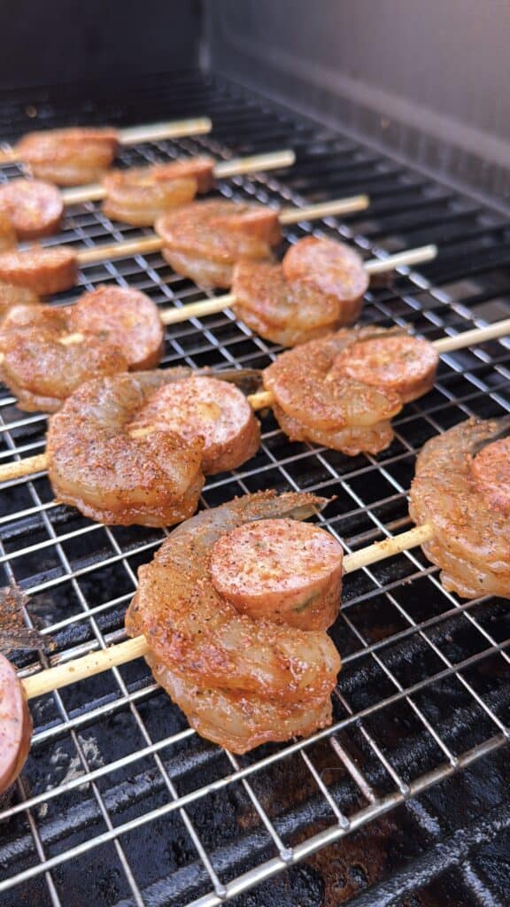 Spicy shrimp and sausage skewers being prepared.