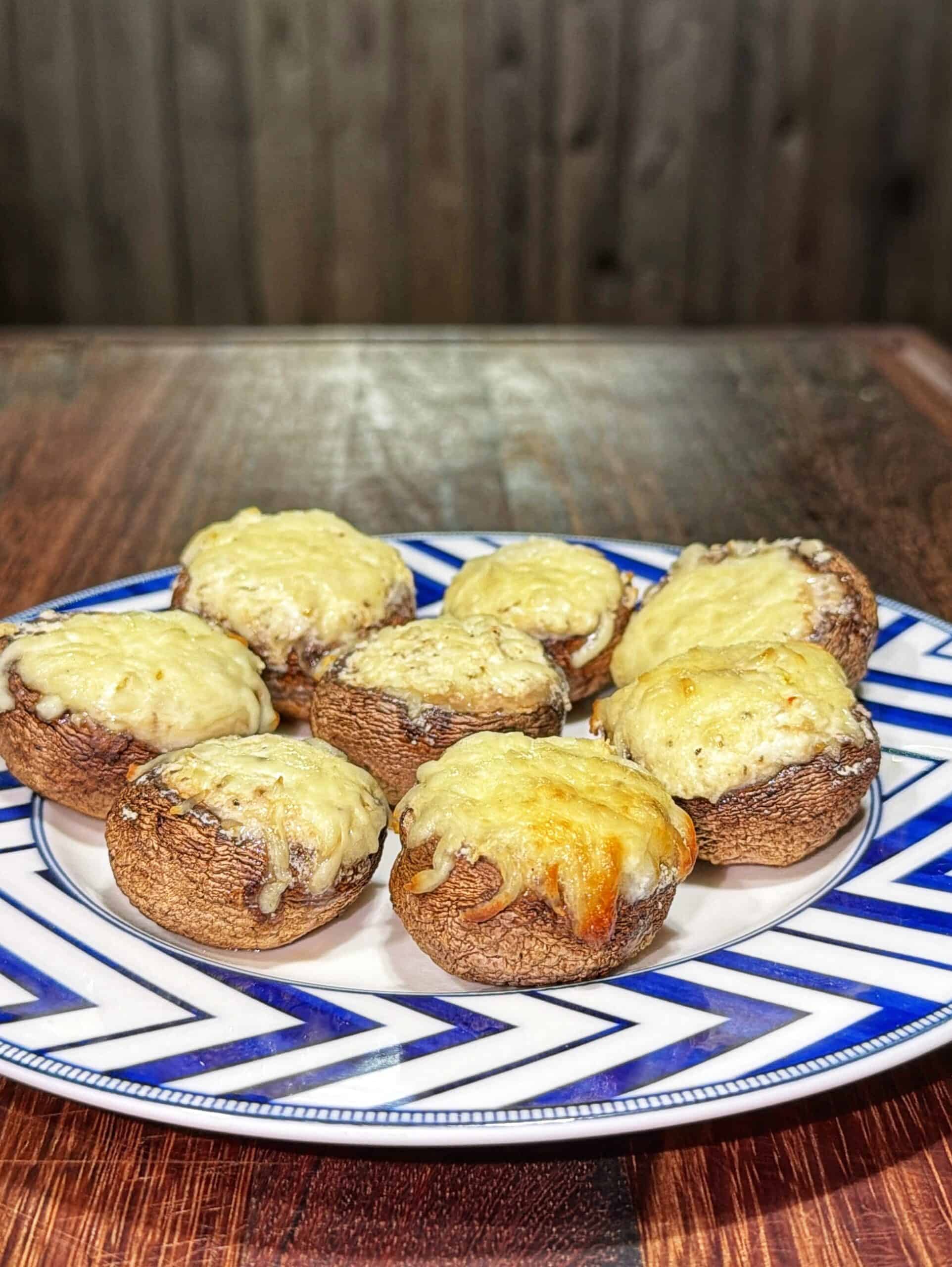 Plate of seven stuffed mushrooms topped with melted cheese.